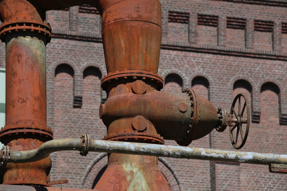 a sad rusty gas pipe wearing a tiny party hat