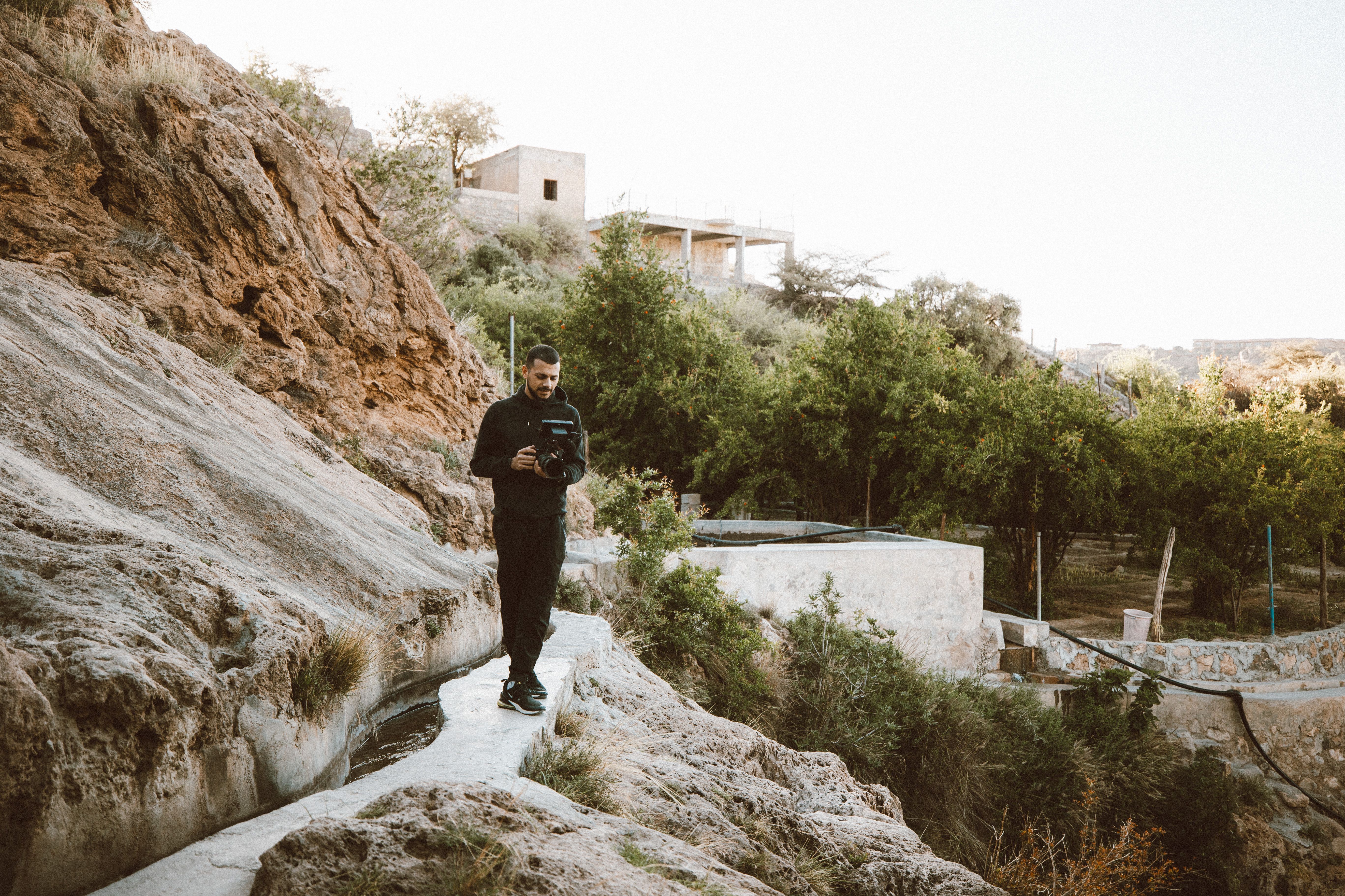 Crystal-clear turquoise pools and lush greenery within Wadi Shab, Oman, inviting travelers to swim.