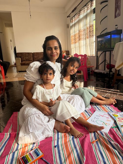 Free A mother and her two children enjoying art activities indoors, surrounded by colorful crayons and drawings. Stock Photo