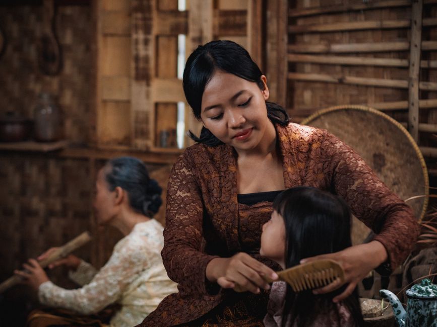 Mother and child in traditional dress enjoying a moment in a Javanese home.