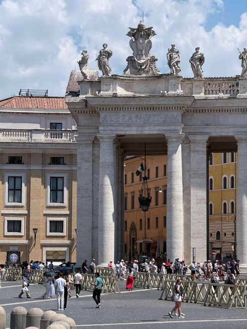 Free Tourists explore St. Peter's Square with vibrant architecture on a sunny day in Rome. Stock Photo