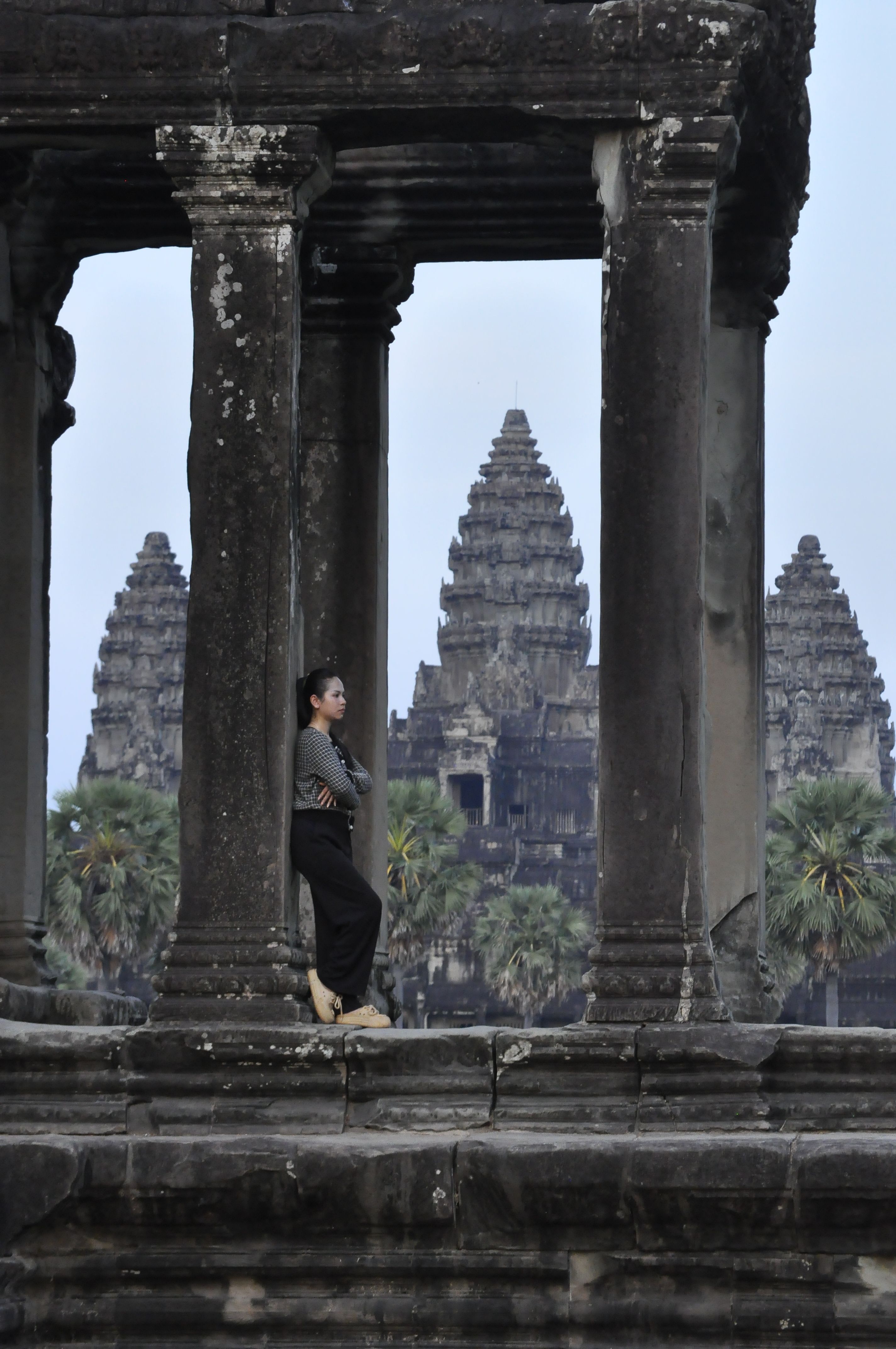 A serene capture of a woman standing at the iconic Angkor Wat temple, Cambodia.