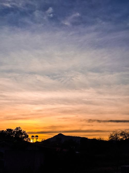 Free Beautiful sunset with a mountainous silhouette and vibrant sky hues. Stock Photo