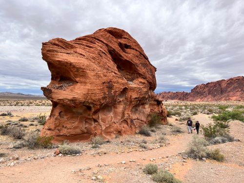 Free Explore the towering red rock formations in a desert landscape with hikers exploring the trail below. Stock Photo