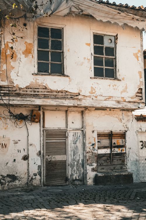 Free A weathered vintage building with peeling paint, showcasing timeless architecture and rustic charm. Stock Photo