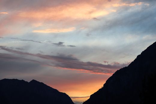 Sunset over silhouetted mountain peaks — photo by Mysara Hassan on Pexels