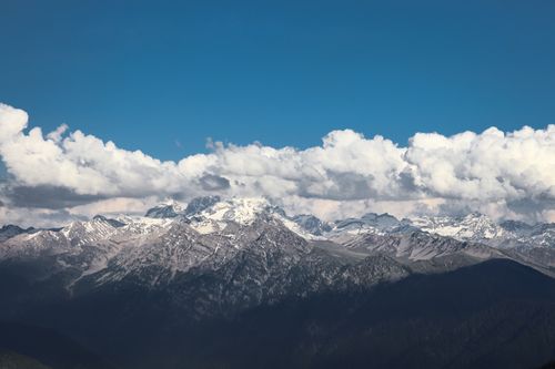Free Breathtaking view of snow-capped mountains under a clear blue sky with clouds. Stock Photo