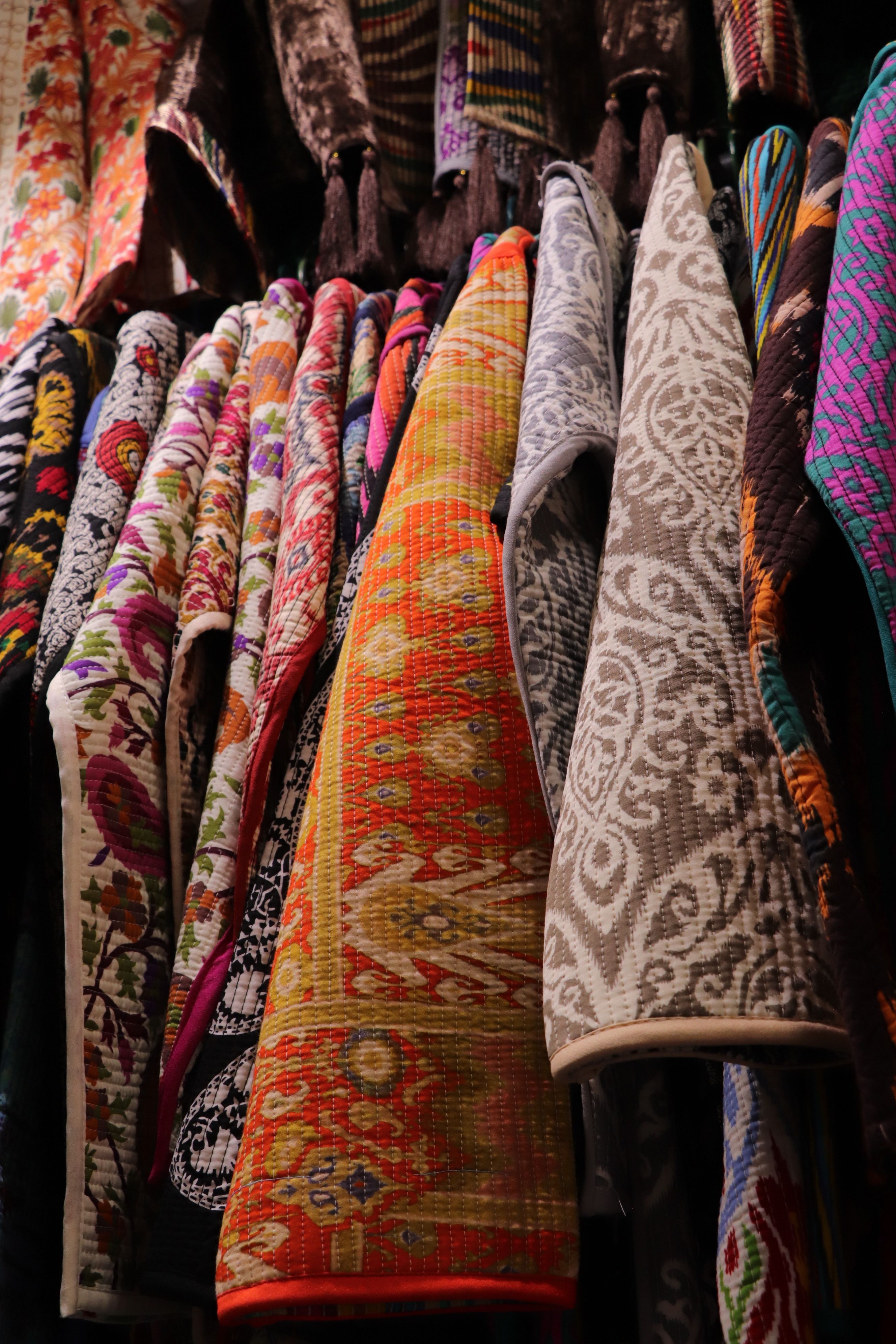 Vibrant display of colorful textile patterns with hanging fabrics in a shop.