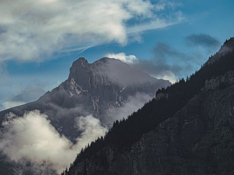 Majestic Swiss Alps with clouds and blue sky in Kandersteg, perfect for nature lovers.