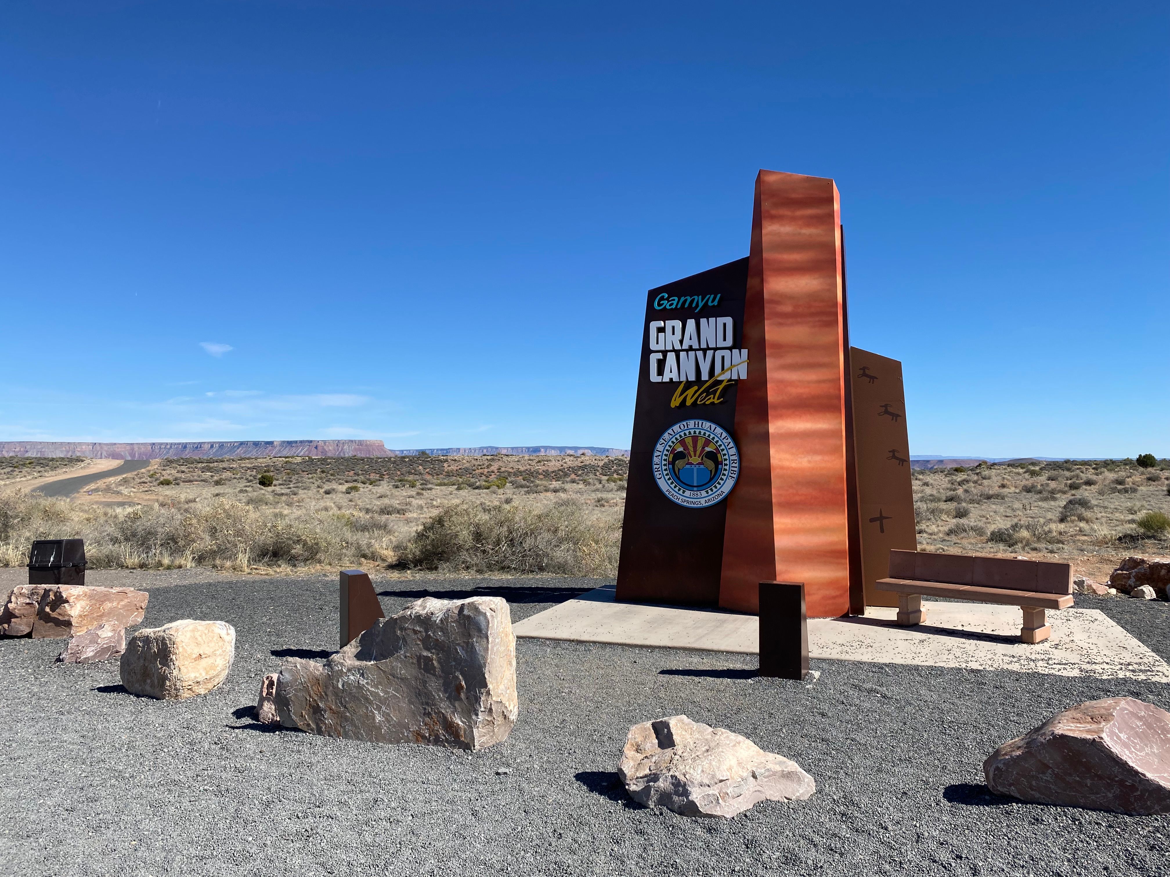 Grand Canyon West entrance sign with rocky desert landscape in Arizona, USA.