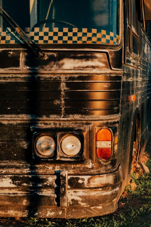 Free Close-up of an old bus with worn paint capturing a warm sunset glow in Brazil. Stock Photo