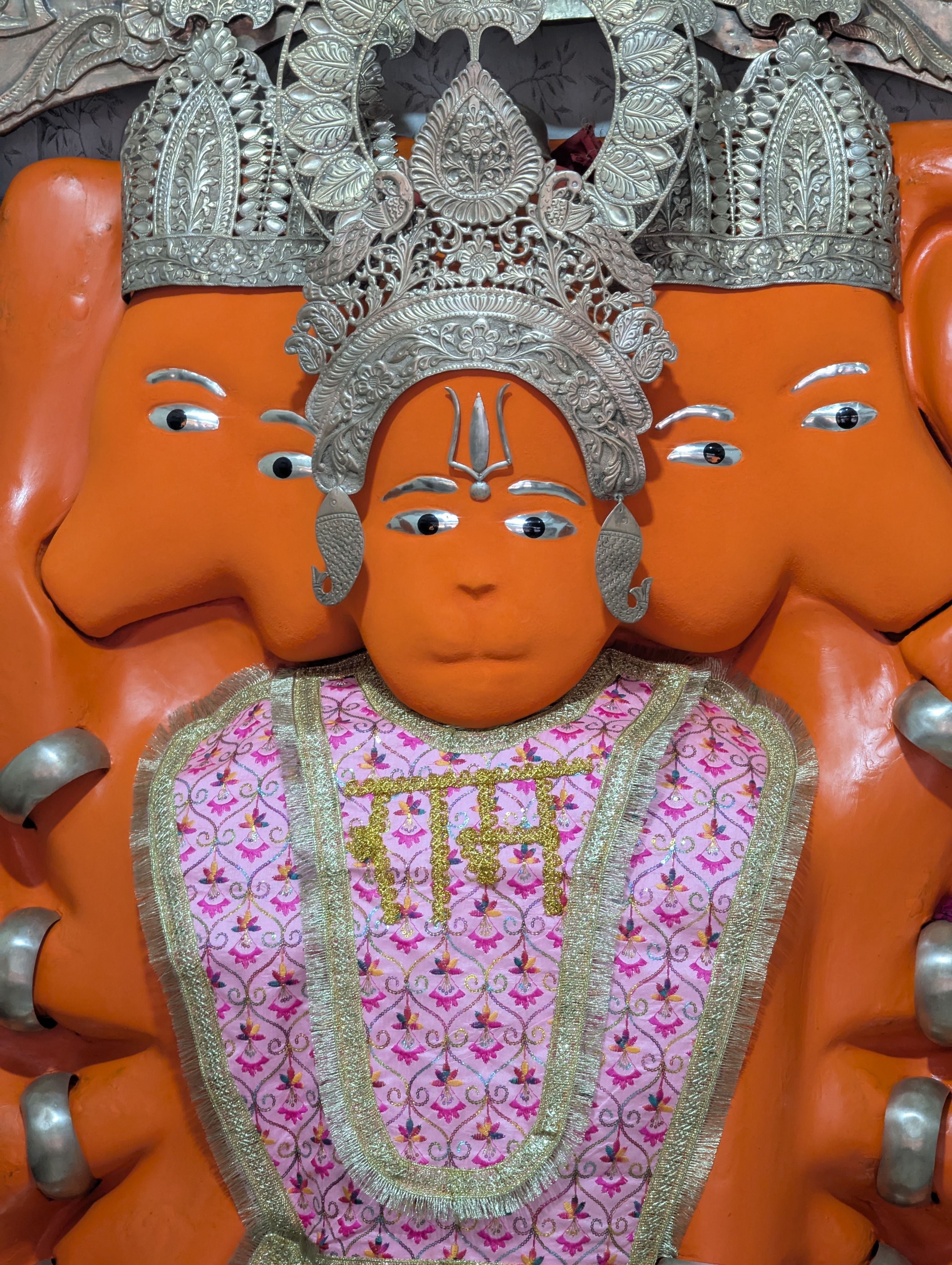 Brightly colored Panchmukhi Hanuman statue with intricate metal crown in Jaipur, India temple.