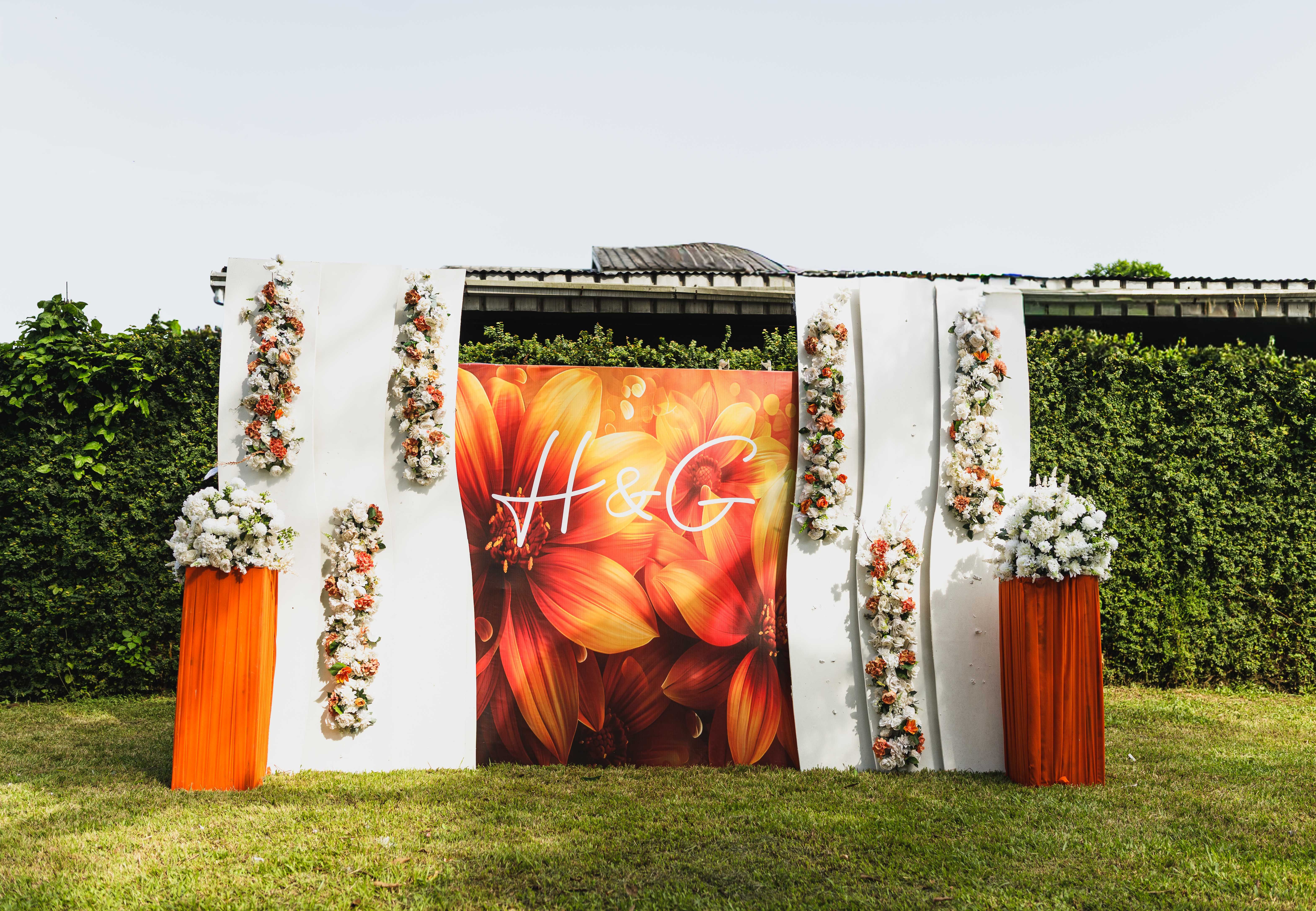 Beautiful floral wedding backdrop with initials in an outdoor garden setting, ideal for elegant celebrations.