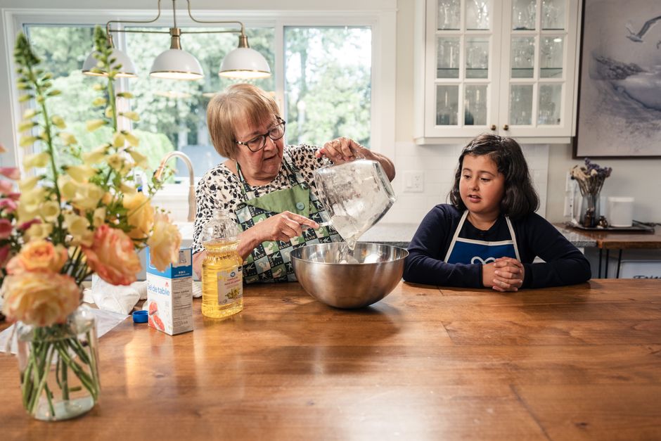 Photo by Jelly Marketing on Pexels A grandmother and granddaughter baking in a kitchen filled with natural light and flowers.