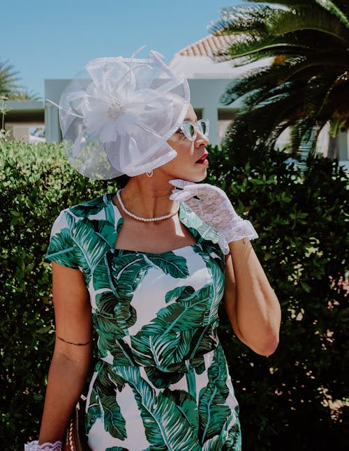 Woman in Green and White Floral Dress With White Flower on Her Head
