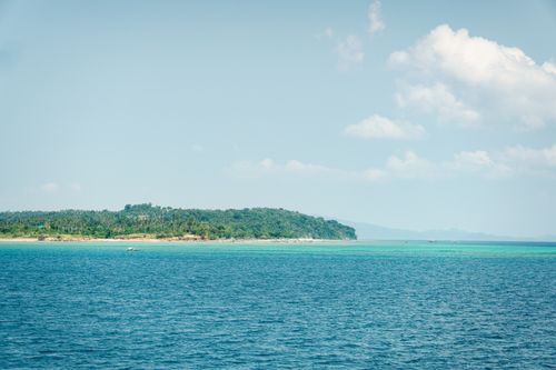 Free Beautiful tropical island coastline with clear blue sea and sky Stock Photo