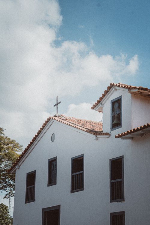 Free A historic church with a cross on the roof, beneath a clear blue sky. Stock Photo
