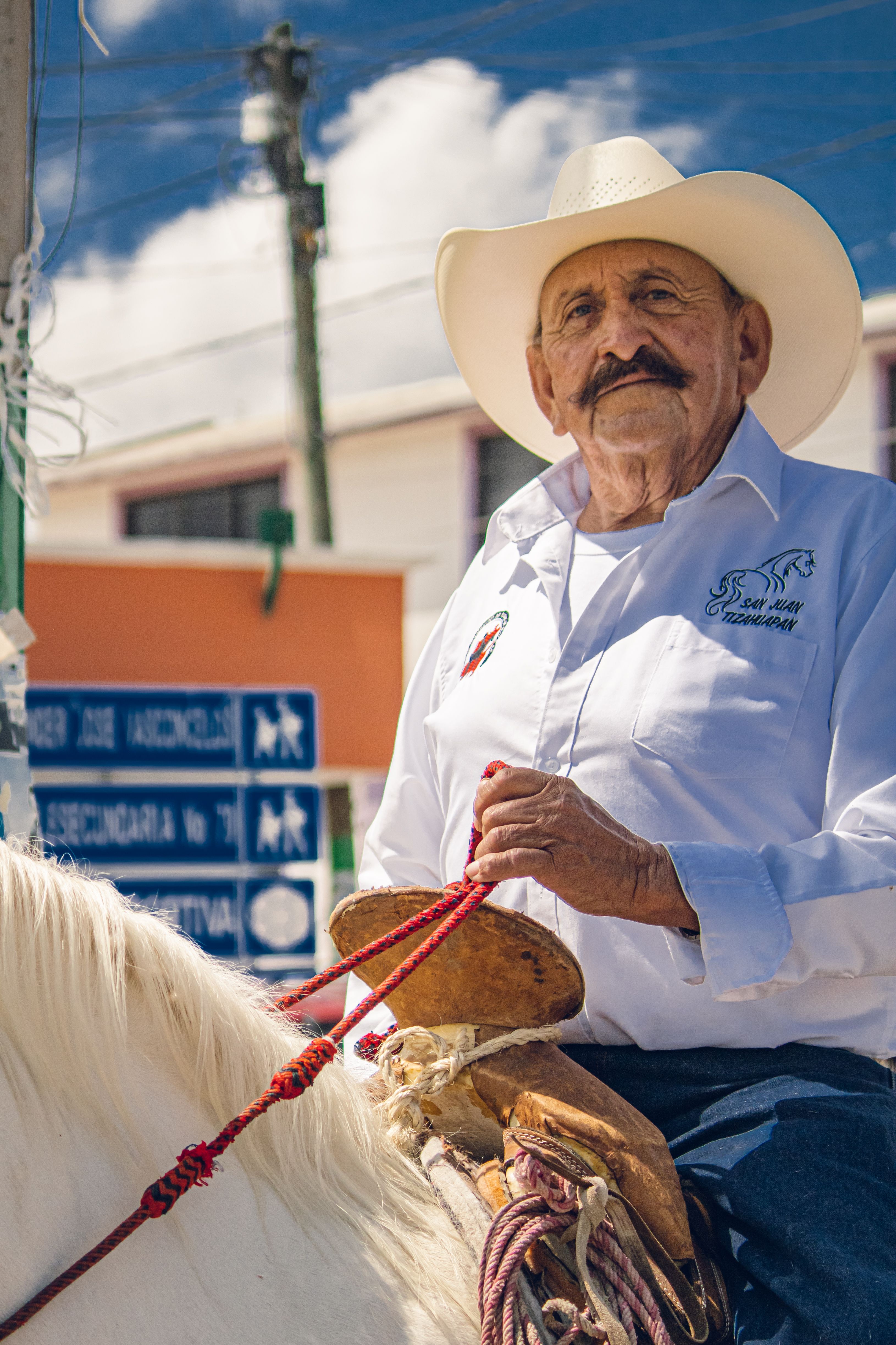 Elderly charro wearing traditional attire riding a horse in Pachuca de Soto, showcasing Mexican culture.