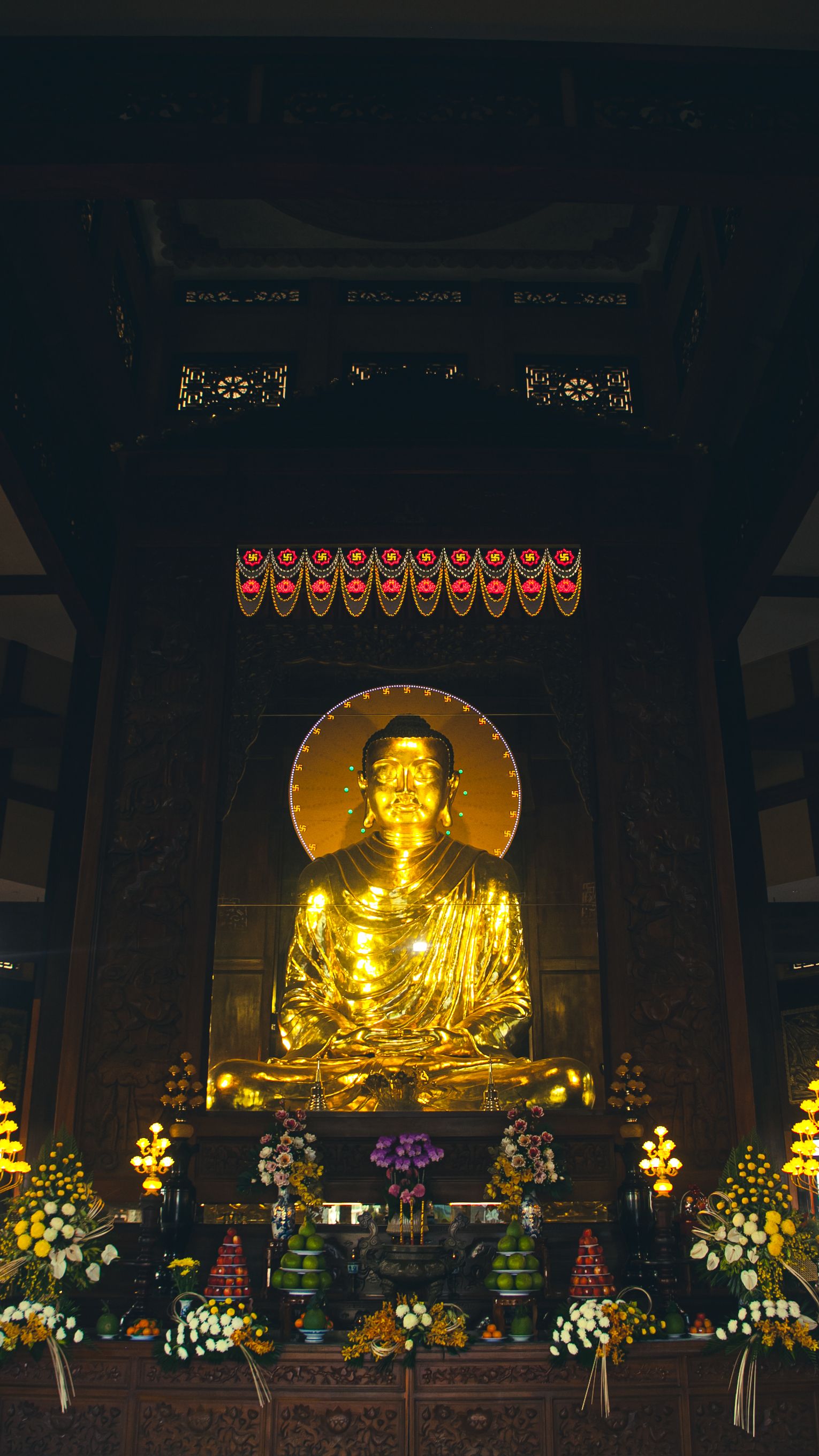 A magnificent golden Buddha statue in a Ho Chi Minh City temple, showcasing religious serenity.