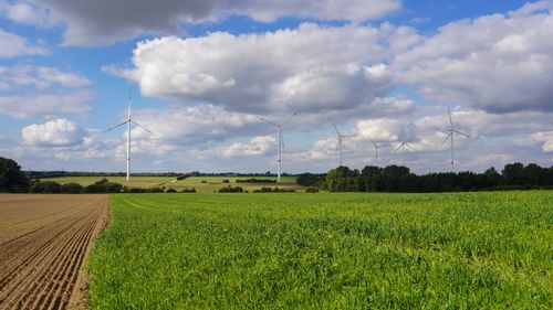 Free Expansive wind turbines overlooking green fields under a cloudy sky in Lütau, Germany. Stock Photo