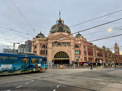 Free Iconic Flinders Street Station in Melbourne with a tram passing by during dusk. Stock Photo