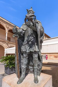 Impressive bronze statue of a medieval knight in Lorca, Spain, under clear blue skies.