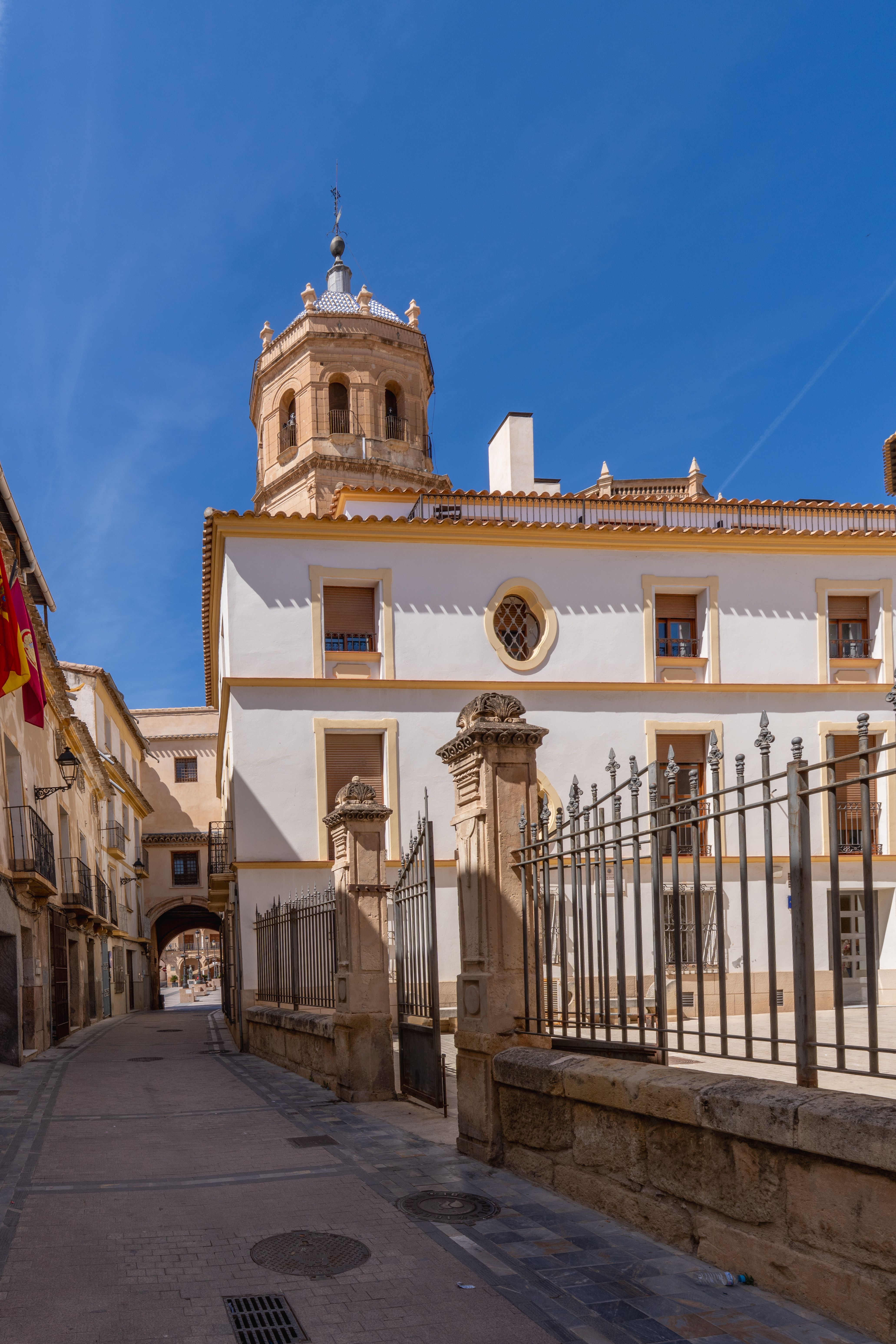 Charming historic street scene with architecture in Lorca, Murcia, under a bright blue sky.