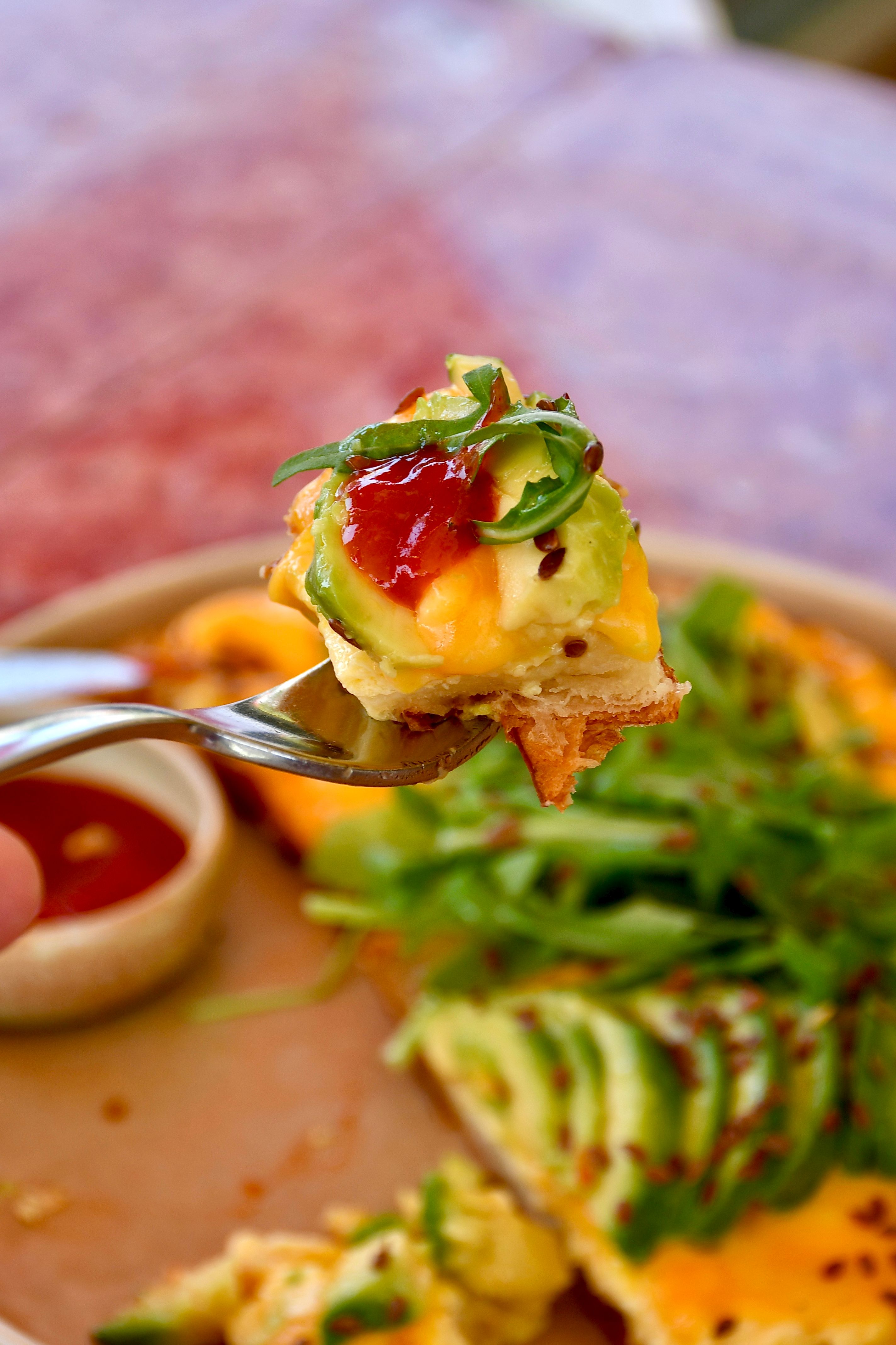 Delicious avocado toast with toppings including cheese, arugula, and tomato jam, perfect for breakfast and brunch.