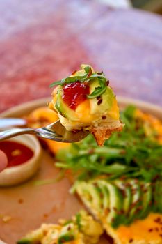 Delicious avocado toast with toppings including cheese, arugula, and tomato jam, perfect for breakfast and brunch.