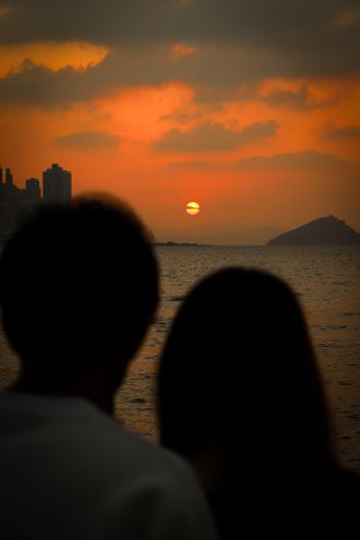 Silhouette of a couple at sunset over the ocean by AY on Pexels