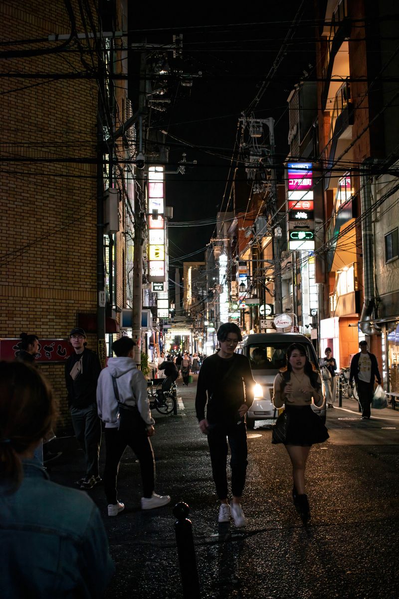Commuters crossing a city street at night — photo by Karolina on Pexels