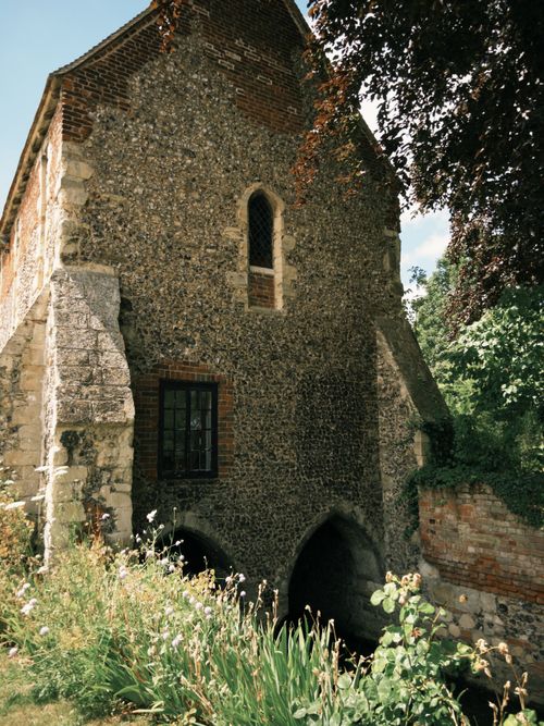 Free Medieval Watergate structure surrounded by lush greenery in Canterbury, England. Stock Photo