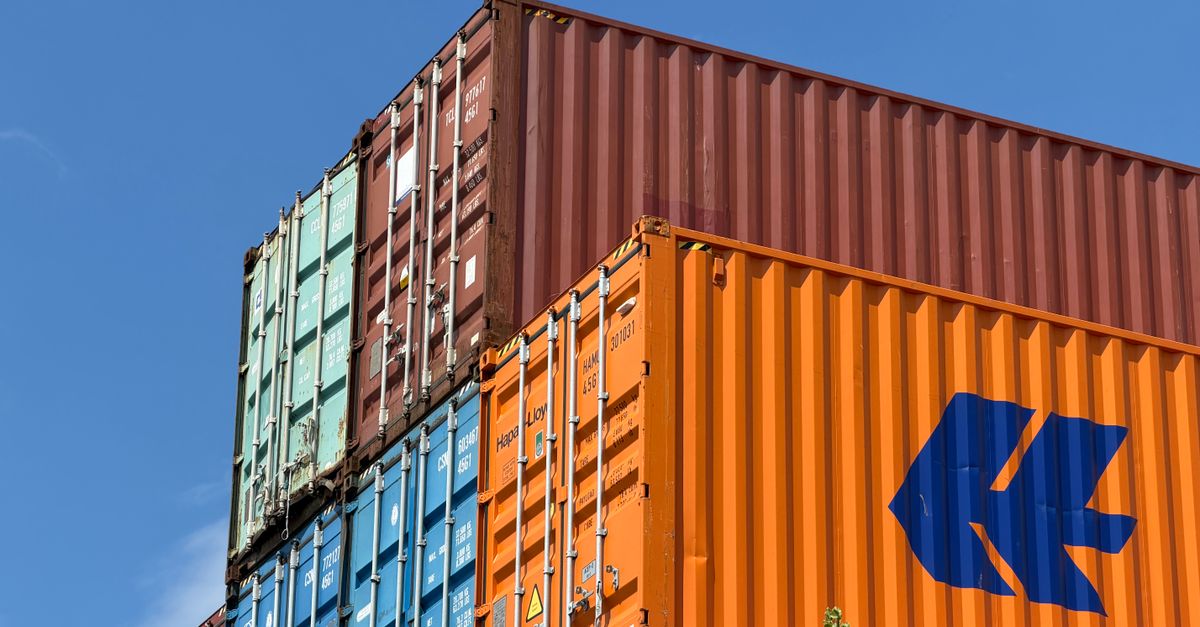 Colorful shipping containers stacked in an outdoor storage area in Germany.