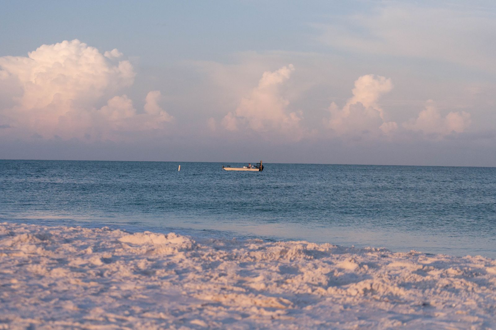 Peaceful beach scene with a boat at sunset in Florida
