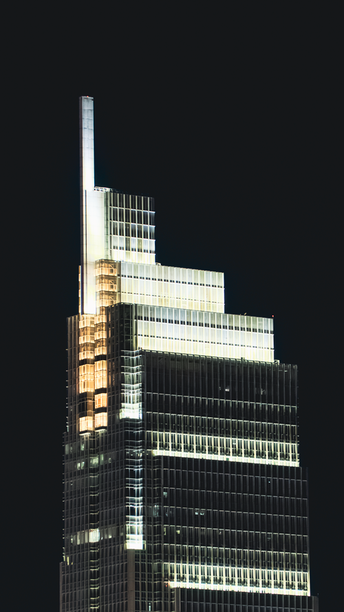 Free Captivating view of a modern skyscraper against a dark night sky. Stock Photo