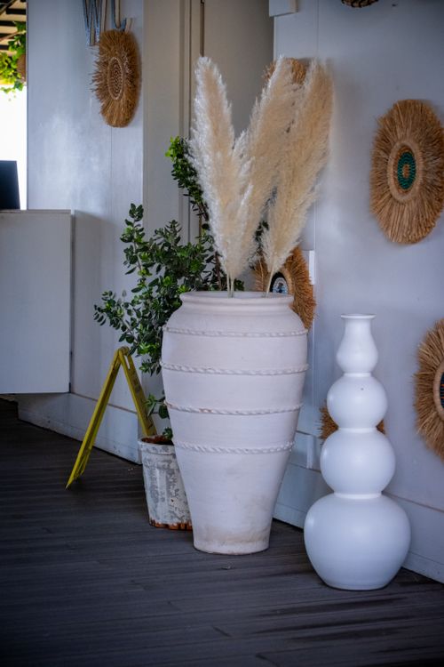 Free Stylish indoor setting featuring a large white vase with pampas grass, surrounded by modern decor elements. Stock Photo