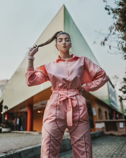 Woman in Pink Long Sleeve Shirt and Pink Pants Holding Her Hair