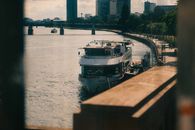 A river cruise ship on the Main River with Frankfurt skyline in the background.