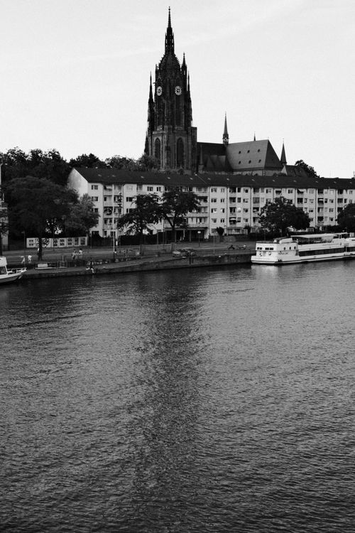 Free Black and white photo of a cathedral by the river in Frankfurt, Germany. Stock Photo