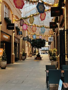 A vibrant shopping arcade in Canterbury with festive decorations and storefronts.