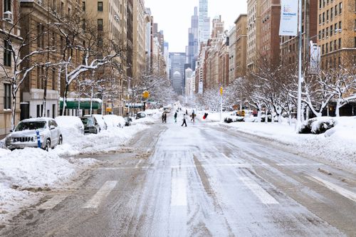 Free A snowy urban street view in New York City during winter, capturing city life and architecture. Stock Photo