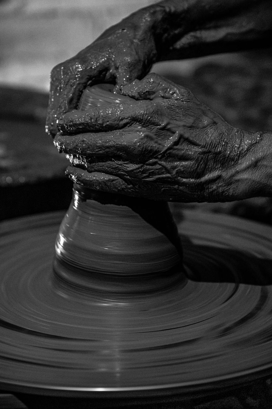 Black and white close-up of hands shaping clay