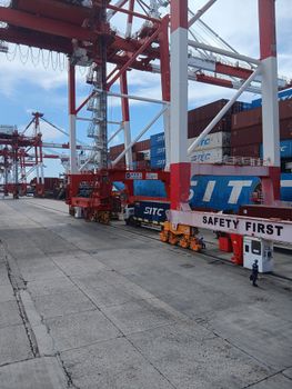 A dynamic view of container cranes and cargo operations at a port in the Philippines.