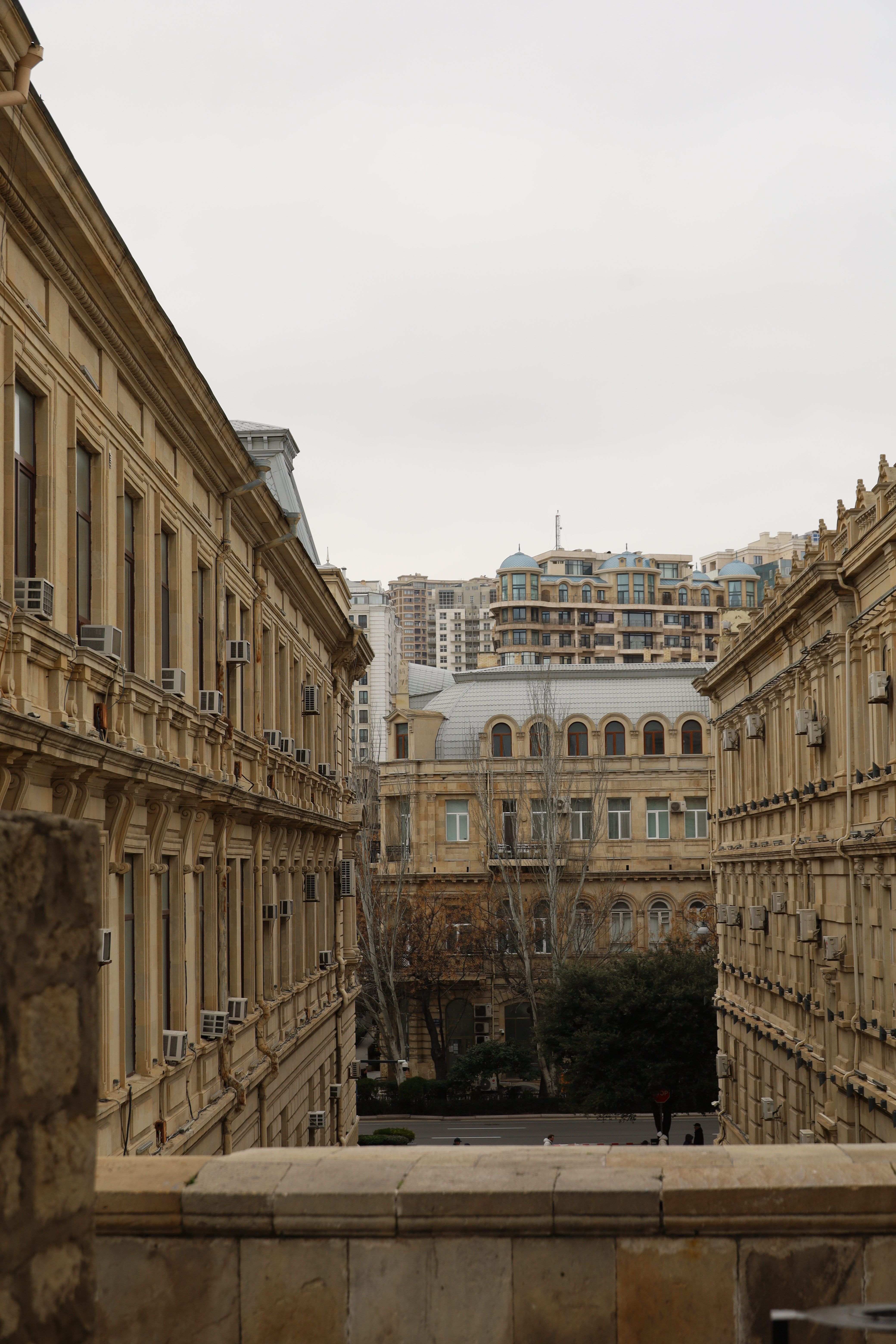 Historic buildings with a backdrop of modern architecture under a cloudy sky.