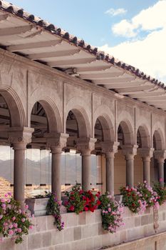 Stone arches with flowers in Cusco's historic colonial architecture.