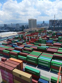 Colorful shipping containers stacked at a bustling Manila port, showcasing industrial logistics.