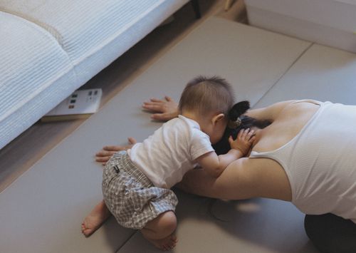 Free A mother and baby bonding on the floor indoors, showcasing love and intimacy. Stock Photo