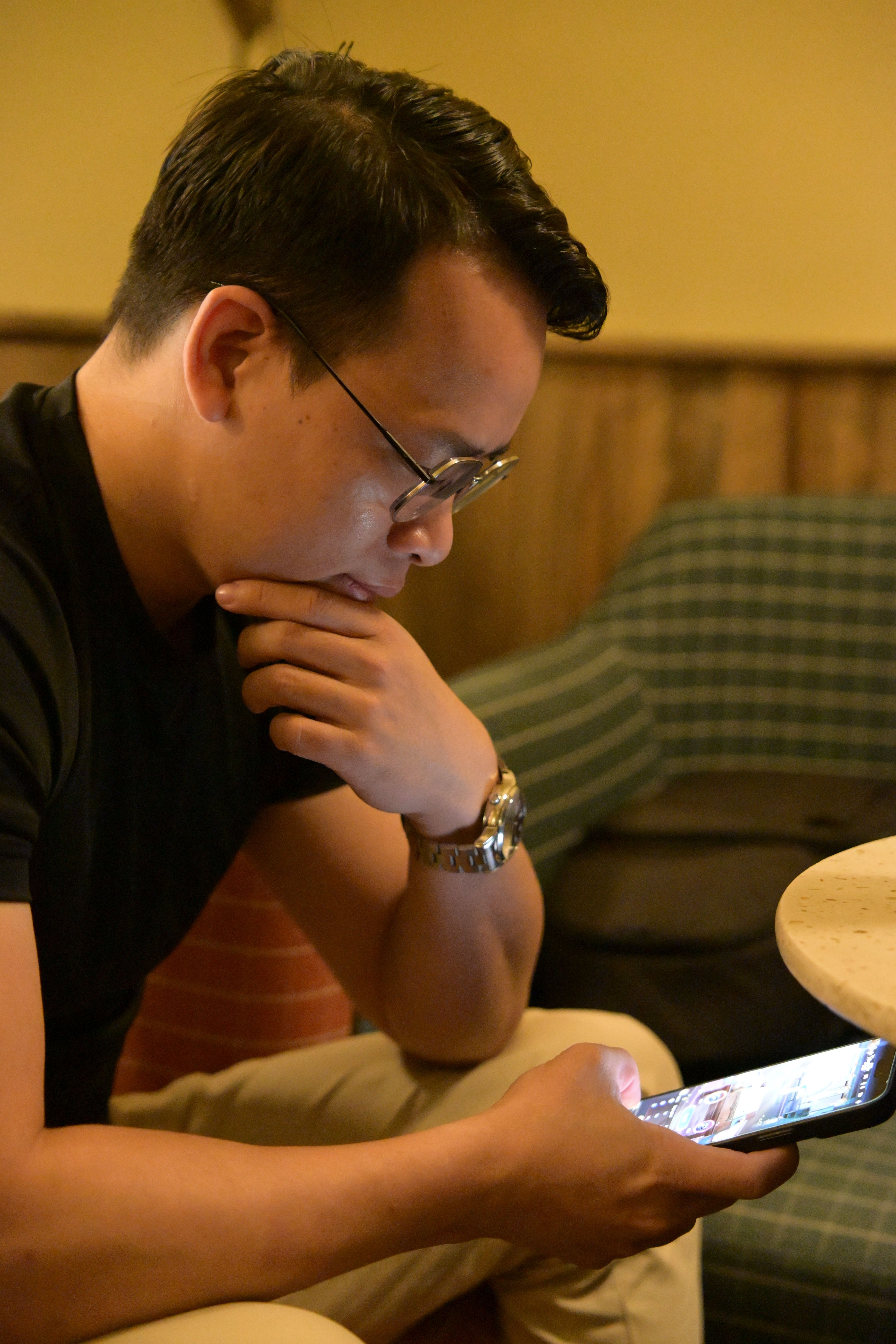 Man in Casual Setting Using Smartphone Indoors