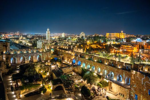 A stunning nighttime view of the illuminated Tower of David and Jerusalem cityscape, showcasing historical architecture.