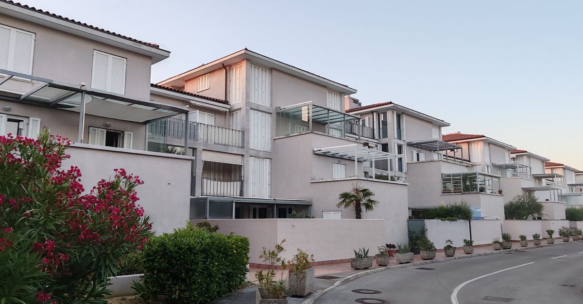 Contemporary apartment complex with outdoor greenery during twilight.